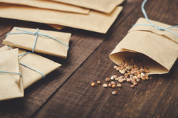 Seed library A few seeds fall out of a paper bag onto a wooden table