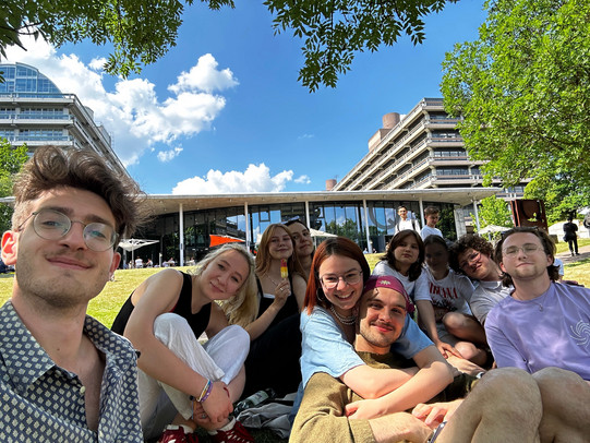 Group of international students sitting on a meadow on the RUB campus