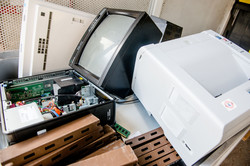 Disused electrical devices An old computer and an old printer lying on paper waste