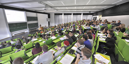 Students on the Master's degree programme in Medical Physics in a lecture theatre with green seating.