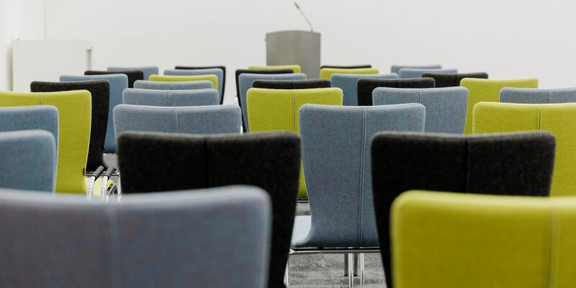 Several rows of gray, green and black chairs.