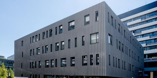 Blick auf den Forschungsbau "Zentrum für Grenzflächendominierte Höchstleistungswerkstoffe", einem modernen, quaderförmigen Bau auf dem Campus der Ruhr-Universität Bochum.