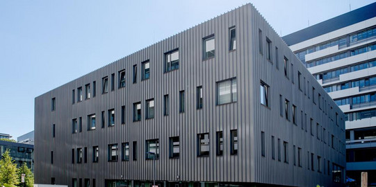 View of the research building ‘Centre for Interfacially Dominated High Performance Materials’, a modern, cuboid building on the campus of the Ruhr University Bochum.