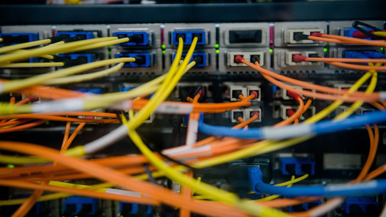 Back of a server with a colorful tangle of cables coming out of it