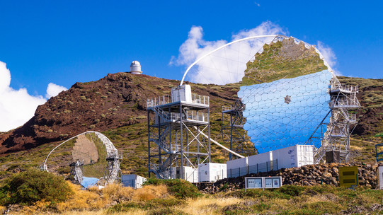 MAGIC telescopes on La Palma, a small and large, futuristic-looking, mirrored telescope