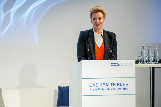 Frau Ina Brandes, Wissenschaftsministerin des Landes Nordrhein-Westfalen, steht am Rednerpult und hält ein Grußwort zur feierlichen Eröffnung des Research Center One Health Ruhr im November 2024.