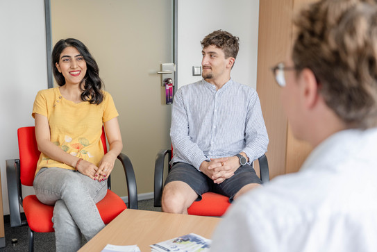 A student, sitting on chairs, talking to a person from the student counselling service.
