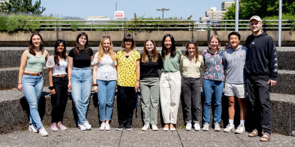 Foto: Ein Gruppenfoto mit neun Studierenden und zwei Mitarbeitenden der Ruhr-Universität Bochum auf dem Campus. 